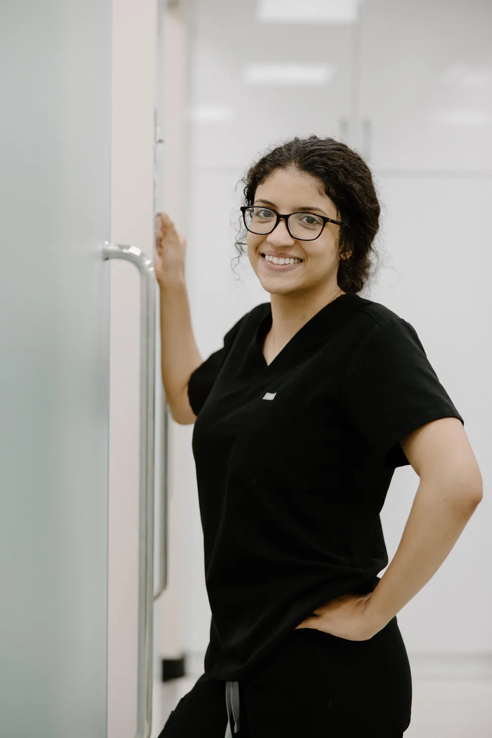 Smiling dental team member in black scrubs