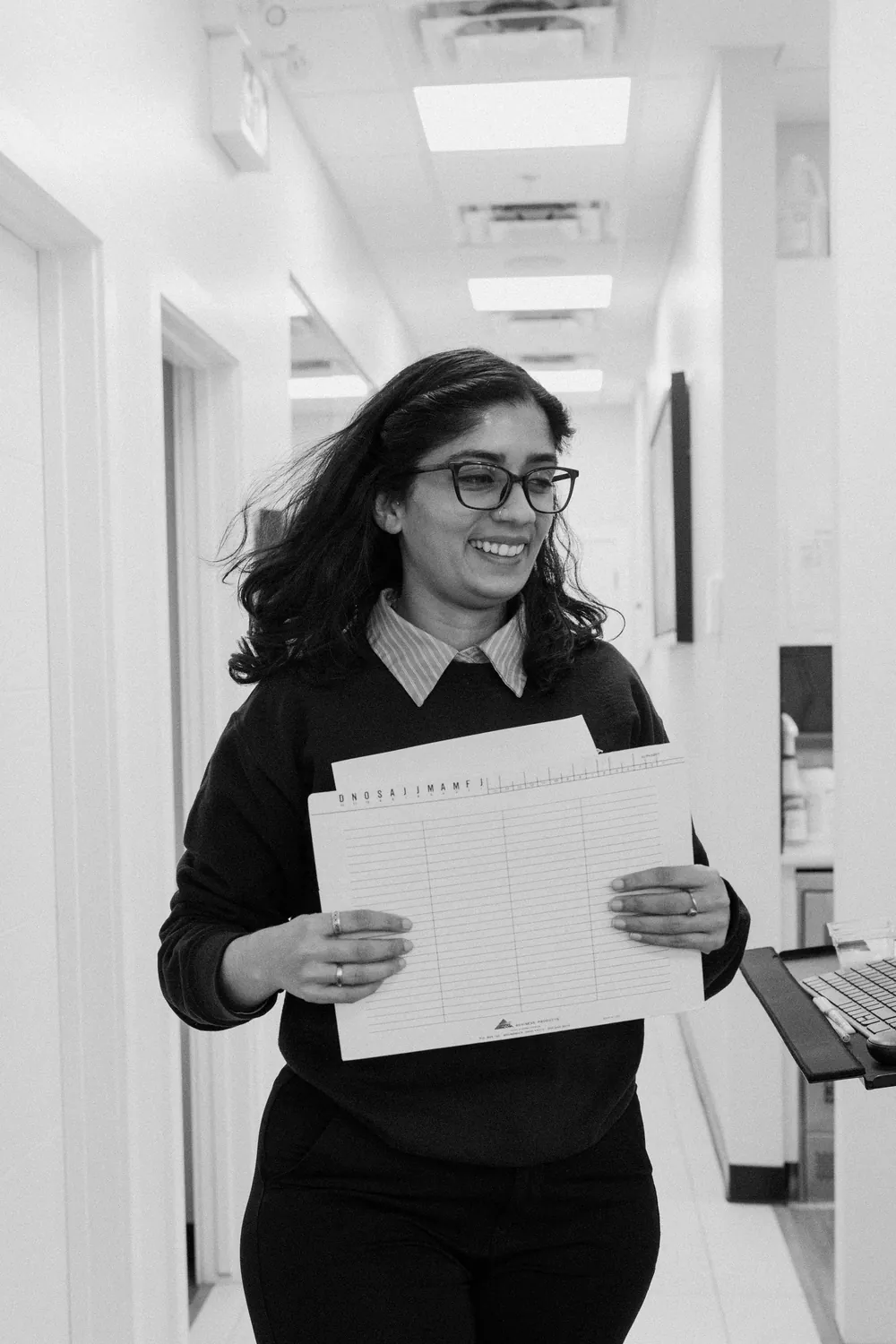 Smiles @ Southgate team member walking down the hallway with patient paperwork