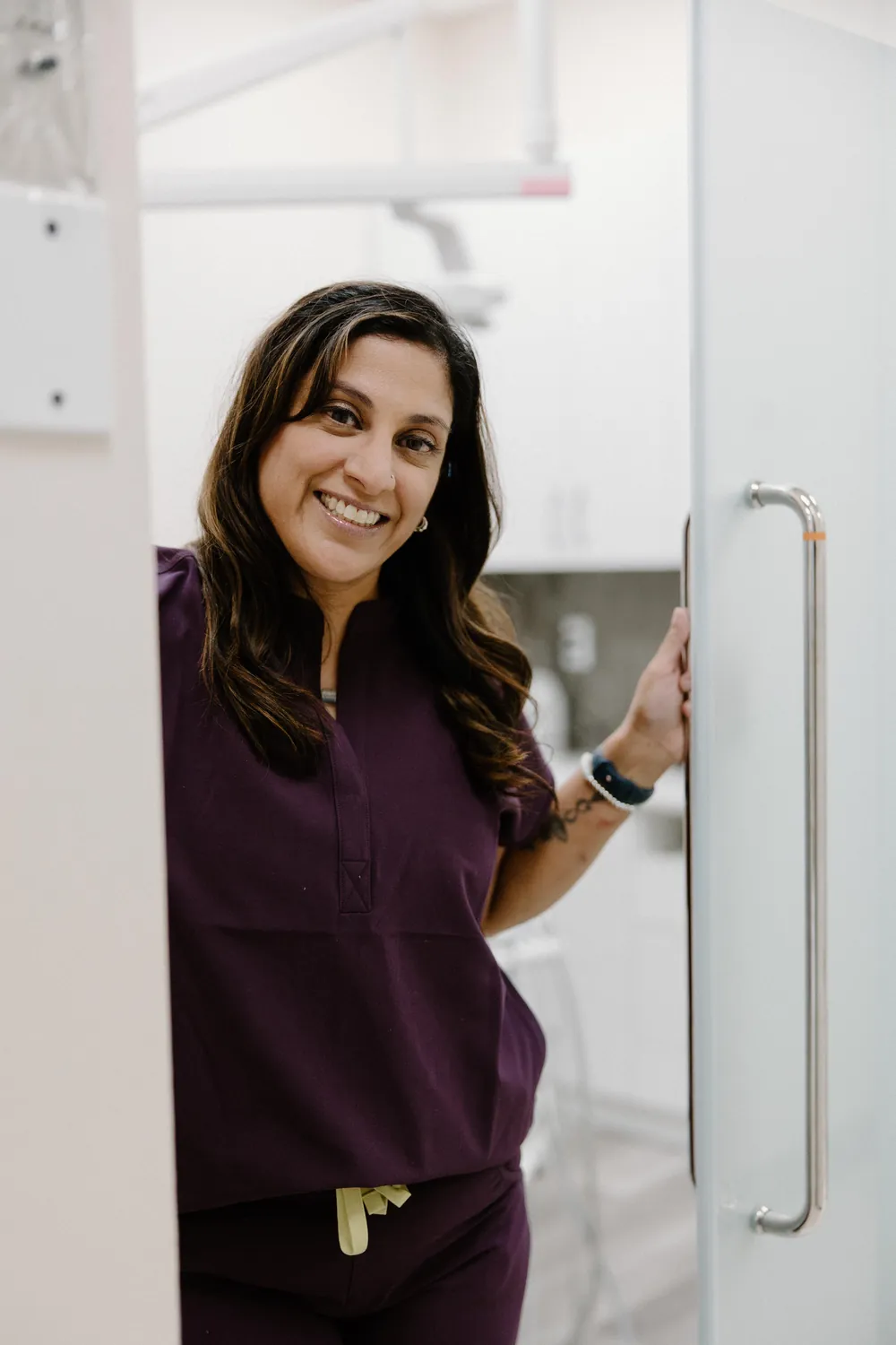 Smiles @ Southgate dental team member in purple scrubs at a treatment room door